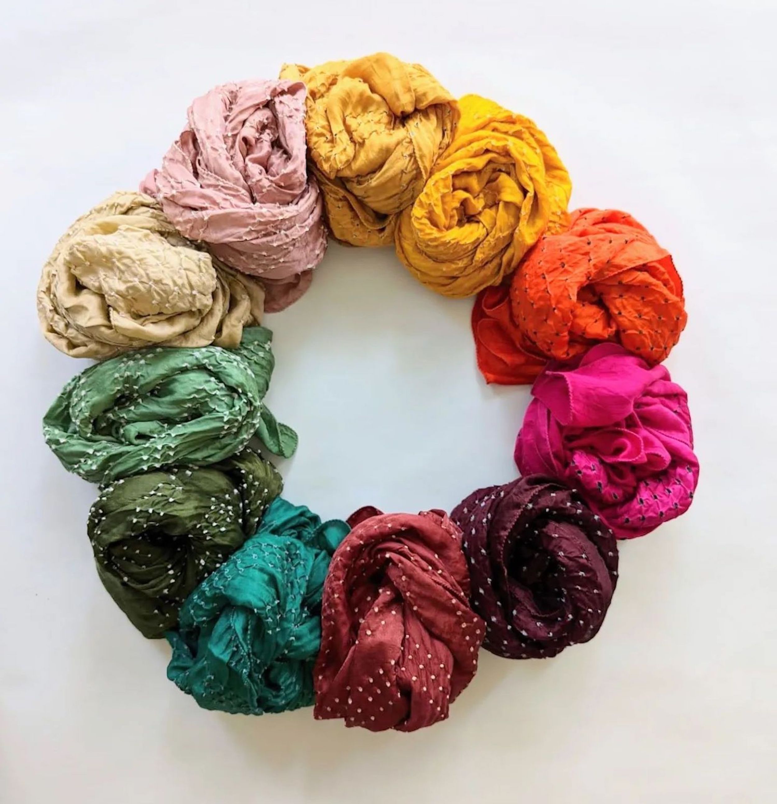 a circle of rainbow colored scarves and bandanas