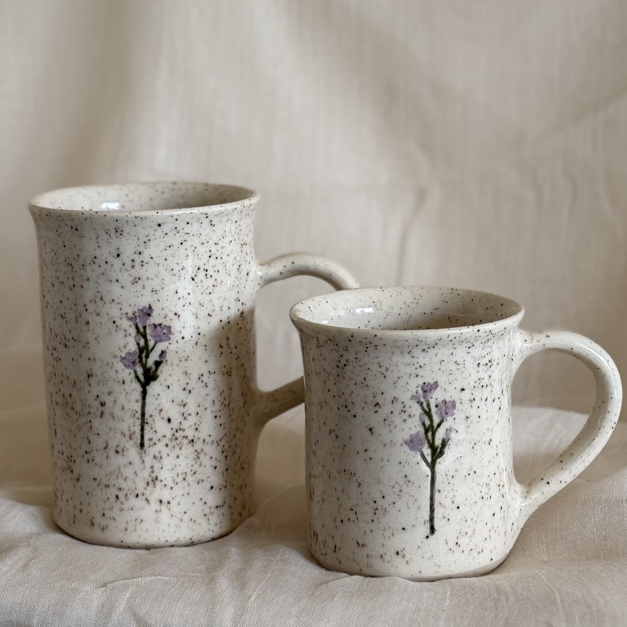 white speckled ceramic mugs with purple flowers